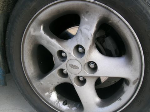 1995 Ford Probe - Close-up of a silver 5-spoke Ford wheel with a Ford logo center cap.