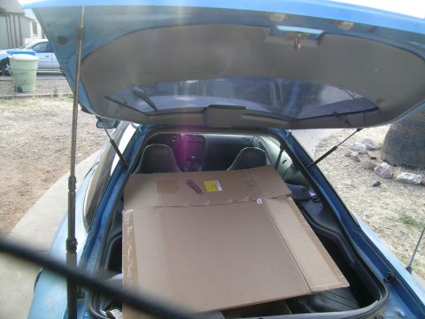 1995 Ford Probe - View inside a blue hatchback's trunk, loaded with cardboard boxes. Exterior shows a driveway and another vehicle.