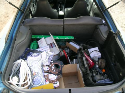 1995 Ford Probe - The trunk of a car is filled with various automotive parts and supplies, suggesting preparation for repairs or upgrades.