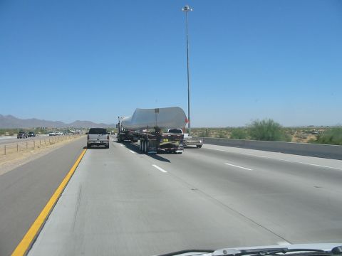 1993 Ford Taurus - A truck transports a large cylindrical object on a highway under a clear blue sky.