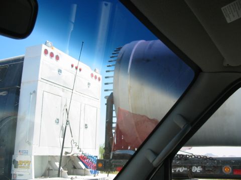 1993 Ford Taurus - Two large trucks are visible on a sunny day, one is a white utility truck and the other appears to be a tanker truck.