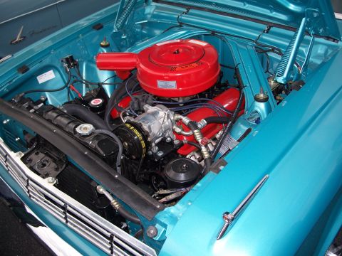 1971 Ford Ranchero - The engine bay of a classic car, a V8 engine and bright turquoise paint.