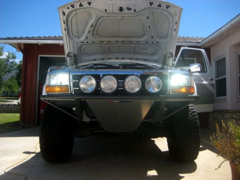 1996 Ford Bronco - The front of a 1996 Ford Bronco is shown with its hood open, revealing an aftermarket bumper equipped with four driving lights.
