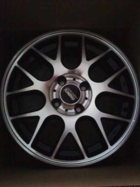 2003 Honda Civic - Aftermarket alloy wheel with 'SPORT TUNING' center cap, shown in a box.