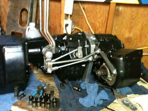 1976 Ford F-100 - A black transmission and differential assembly is shown on a workbench with various tools and shop rags.