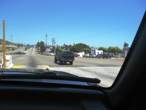 1986 Ford Bronco - A dark SUV is seen driving away on a sunny day with other vehicles present.