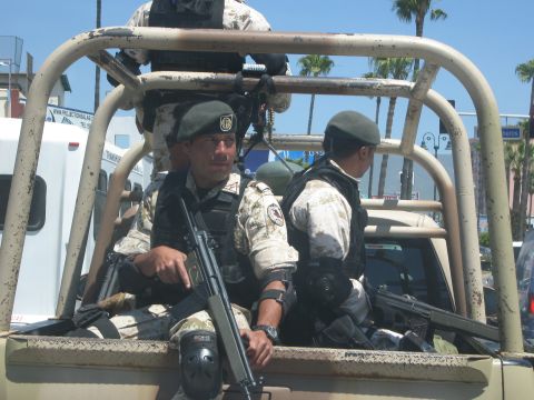 1986 Ford Bronco - Several armed individuals are positioned in the bed of a utility vehicle, suggesting a security or patrol operation.