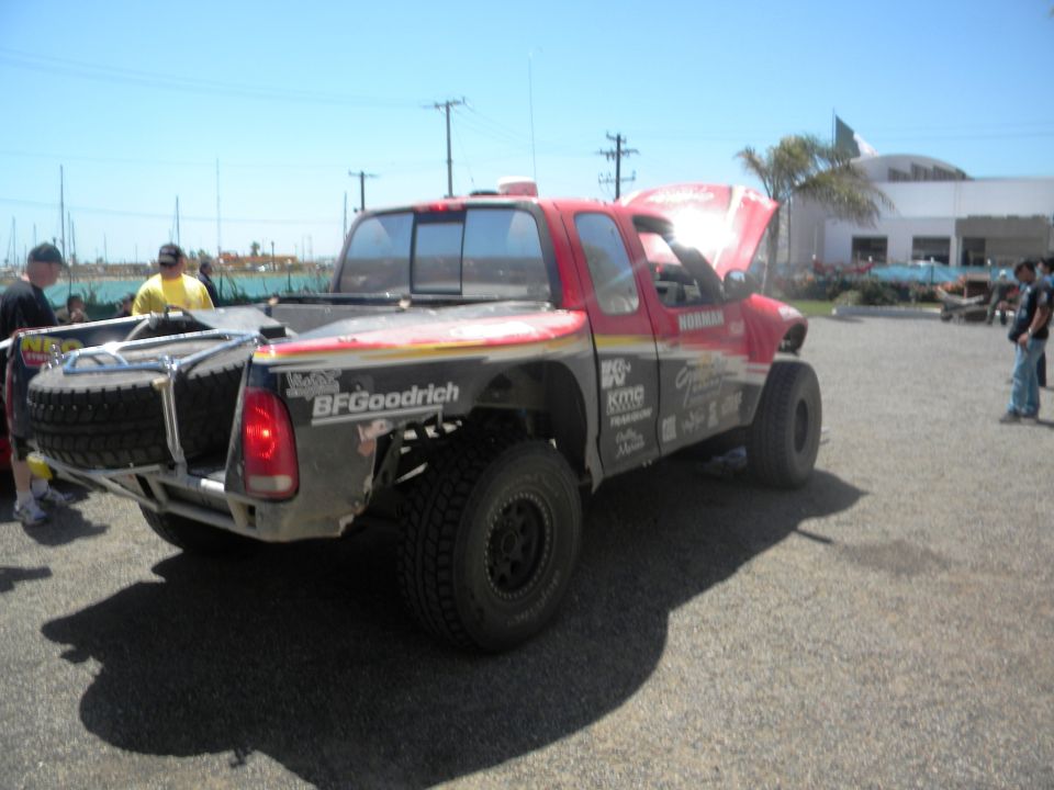 Red off-road pickup truck with hood open, spare tire mounted on rear, BFGoodrich branding