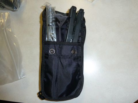 1992 Ford Mustang - A black pouch contains various tools, including a metal rod and two multi-tools, suggesting it's a repair or maintenance kit.