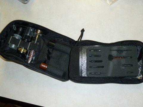1992 Ford Mustang - A black zippered pouch holds various cleaning items and tools, such as small bottles and a brush, laid out for inspection.