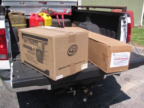 2008 Ford F-250 - Tailgate of a white pickup truck loaded with boxes and fuel cans.