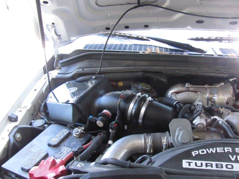 2008 Ford F-250 - The engine bay of a truck, showing the intake system and turbocharger components. "Power Stroke V8" is visible.