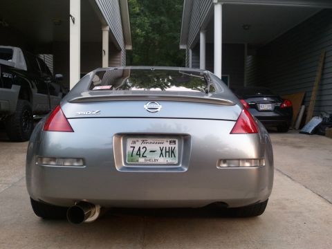 1996 Ford Bronco - A silver Nissan 350Z is parked in a driveway, showing its rear end and license plate.