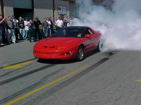 1991 Ford Bronco - A red sports car creates a massive smoke cloud during a burnout event.