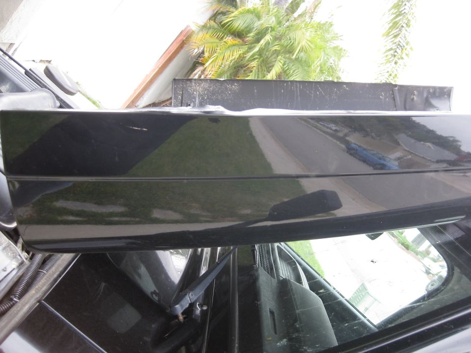 View from inside a car looking up at the roofline and out the rear window. Palm trees are visible outside