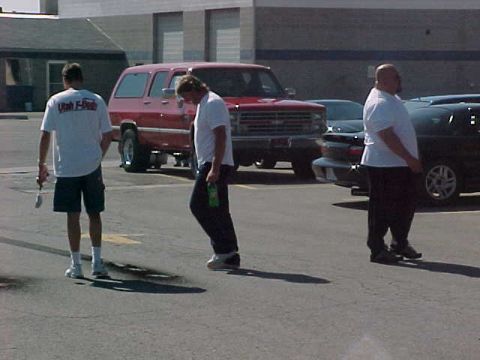 1991 Ford Bronco - A red 1991 Ford Bronco is parked in a lot with two men standing around it.