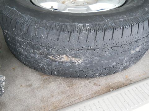 2006 Ford E350 - A close-up of a damaged tire, showing a significant gash on its sidewall.