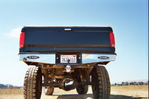 1992 Ford F-250 - This black 1992 Ford F-250 pickup truck is viewed from the rear, showing its chrome bumper and California license plate.