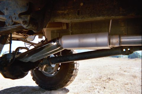 1992 Ford F-250 - The rear axle, driveshaft, and exhaust system of a truck are visible from a low angle.