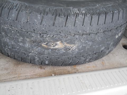 2006 Ford E350 - A damaged tire with exposed internal cords and worn tread is visible.