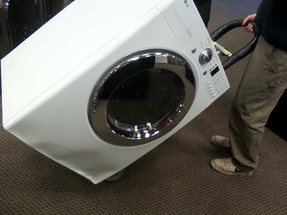 White LG washing machine with a chrome door being moved on a dolly