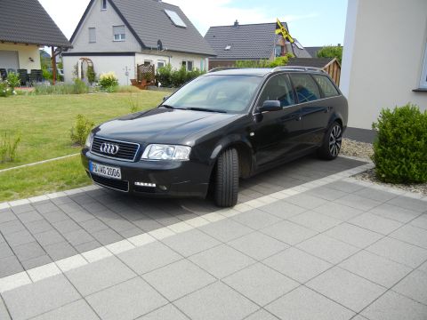 2003 Audi A6 - This black Audi wagon is parked on a paved driveway in front of a residential building.