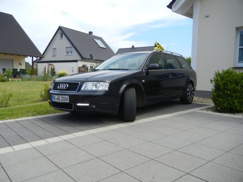 2003 Audi A6 - A black Audi A6 Avant is parked on a paved driveway in front of a house, with a yellow taxi sign on the roof.