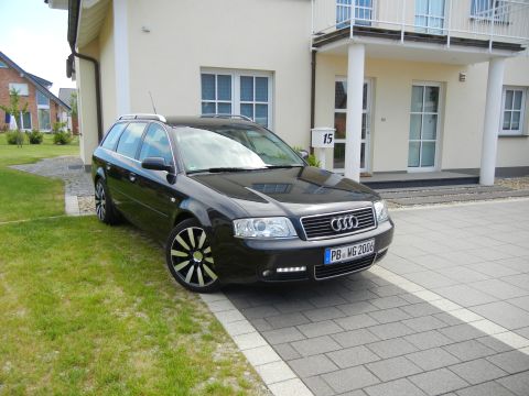 2003 Audi A6 - This black Audi A6 Avant is parked on a paved driveway in front of a modern house.