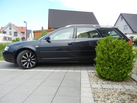 2003 Audi A6 - A black station wagon is parked in front of houses and a manicured bush.