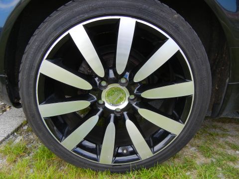 2003 Audi A6 - A close-up of a car's alloy wheel and tire, with grass and gravel visible.