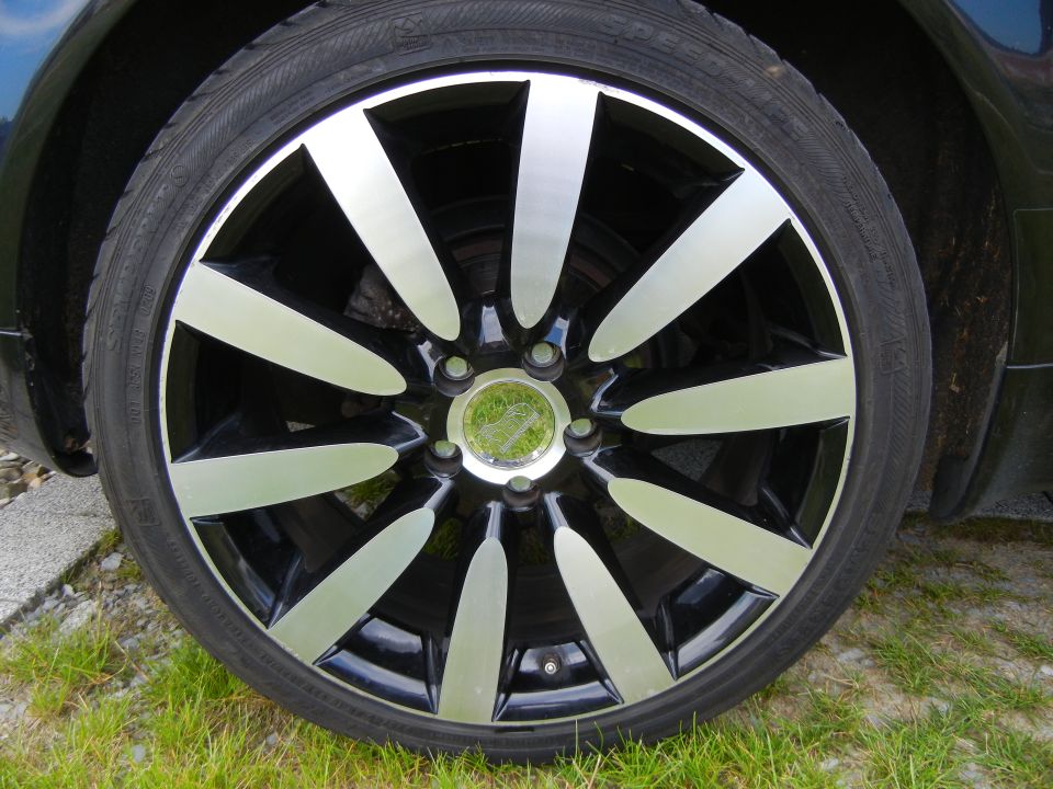 Black and silver alloy wheel with a tire, close-up view