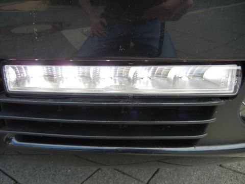 2003 Audi A6 - Close-up of a vehicle's front bumper, showing a fog light assembly and grille details. Text on the fog light indicates 'Cella'.