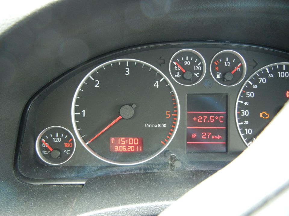 Car dashboard with tachometer, speedometer, temperature gauge, fuel gauge, and digital display showing time and date
