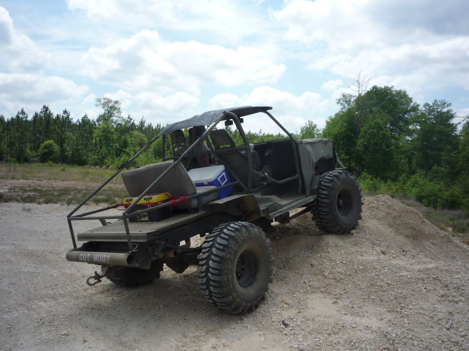 Custom off-road vehicle with large tires and open-air design, rear view