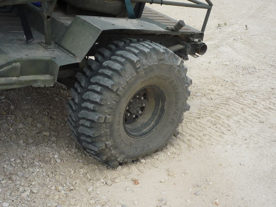 Off-road vehicle's large, aggressive tire and rear fender assembly on a dirt surface