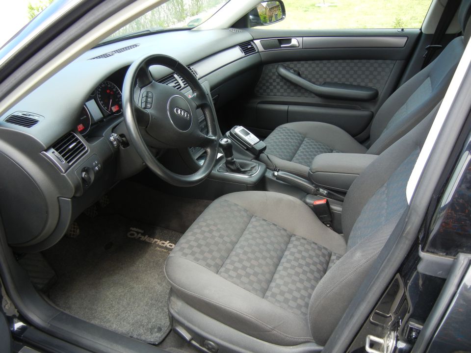 Interior view of a 2003 Audi A6 showing the dashboard, steering wheel, seats, and center console