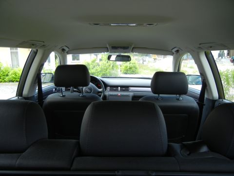2003 Audi A6 - The interior of an Audi A6 is shown from the back seat, looking towards the front dashboard and driver's area.