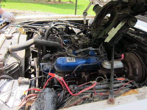 1991 Ford LTD Crown Victoria - Jumper cables are connected to the battery terminals in the engine bay.