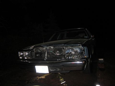 1991 Ford LTD Crown Victoria - A 1991 Ford Crown Victoria LTD shows significant damage to its front end, with the hood open and engine components exposed.
