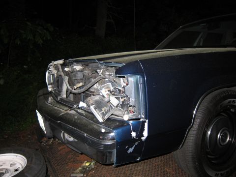 1991 Ford LTD Crown Victoria - The front end of a 1991 Ford Crown Victoria LTD shows significant damage to the headlight and bumper area.