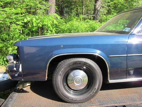 1991 Ford LTD Crown Victoria - Front fender and wheel of a blue 1991 Ford Crown Victoria LTD.