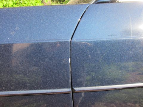 1991 Ford LTD Crown Victoria - Detail shot of a car's door seam and body trim, showing the paint finish.
