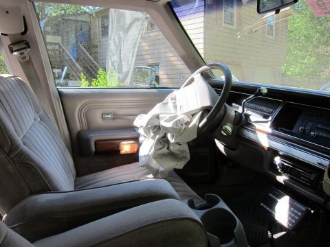 1991 Ford LTD Crown Victoria - The interior of a 1991 Ford Crown Victoria LTD, showing the driver's side and a deployed airbag.