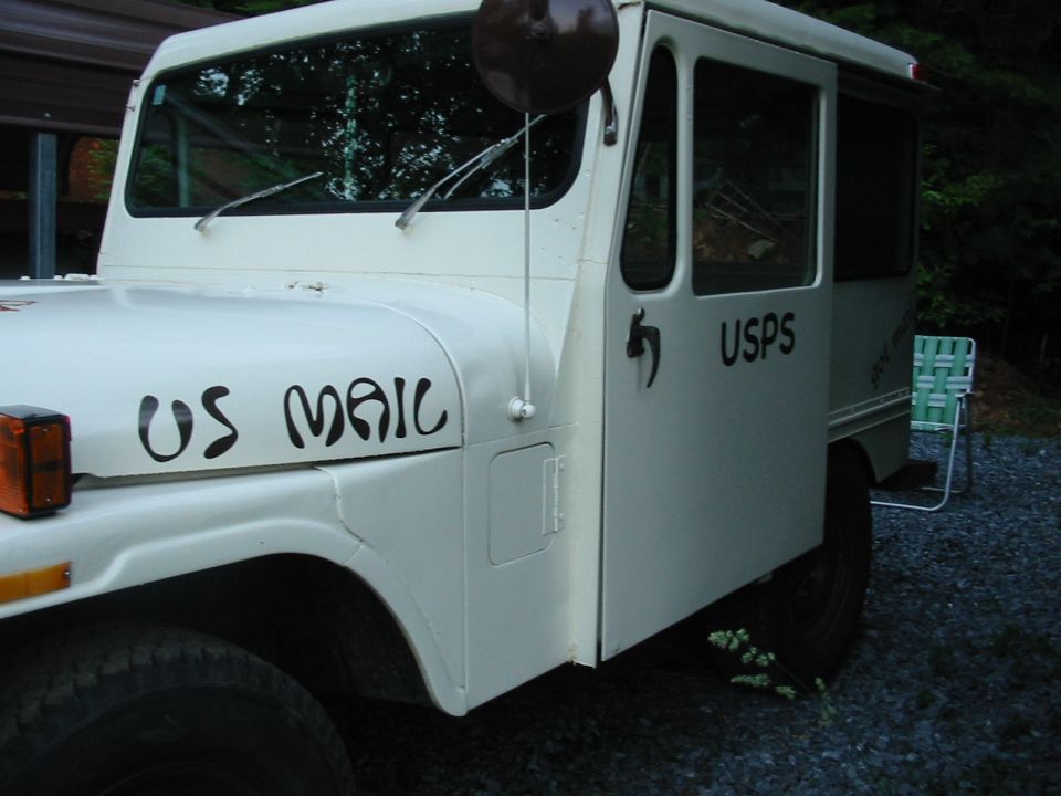 White USPS mail jeep with 'US MAIL' on fender and 'USPS' on door