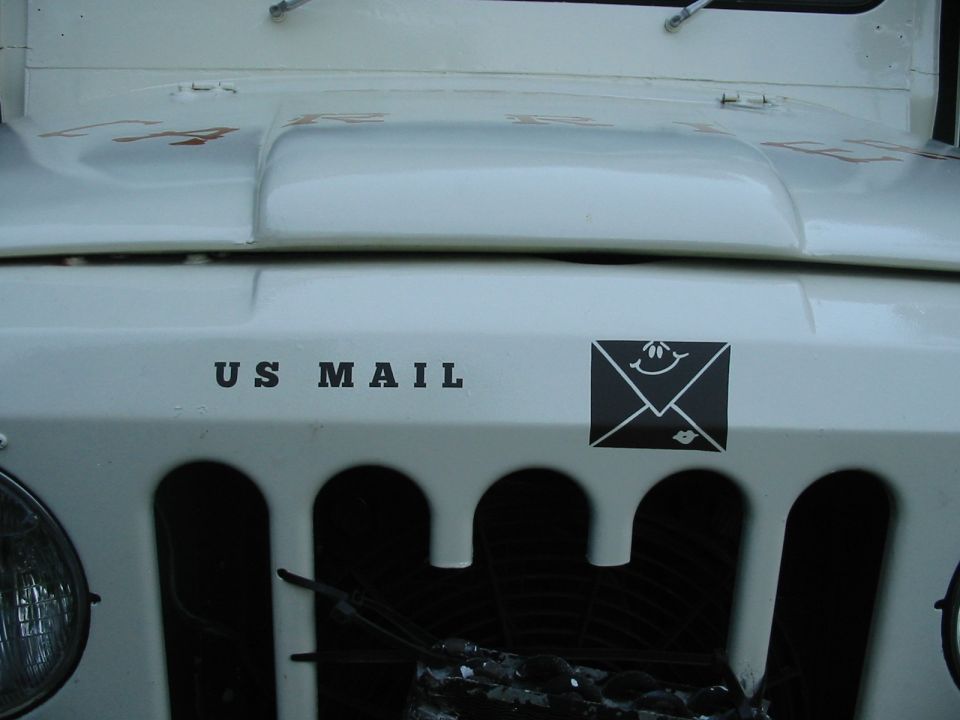 White Jeep with 'US MAIL' on front and an envelope sticker