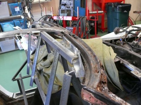 1976 Chevrolet Corvette - A car's frame is undergoing repairs, with visible rust and temporary metal supports holding it in place.