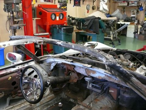 1976 Chevrolet Corvette - The interior of a disassembled Corvette is shown, with the engine bay visible behind the dashboard.