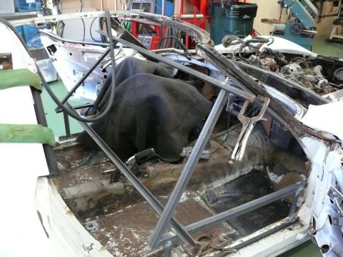 1976 Chevrolet Corvette - The interior of a 1976 Chevrolet Corvette is shown during a repair process, with metal bracing supporting the structure.