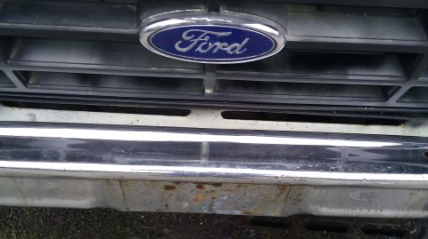 1984 Ford Bronco - Front view of a Ford vehicle's grille and bumper, showing the Ford emblem.