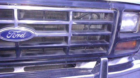1984 Ford Bronco - Close-up of the Ford emblem and grille on a truck from the early 1980s.